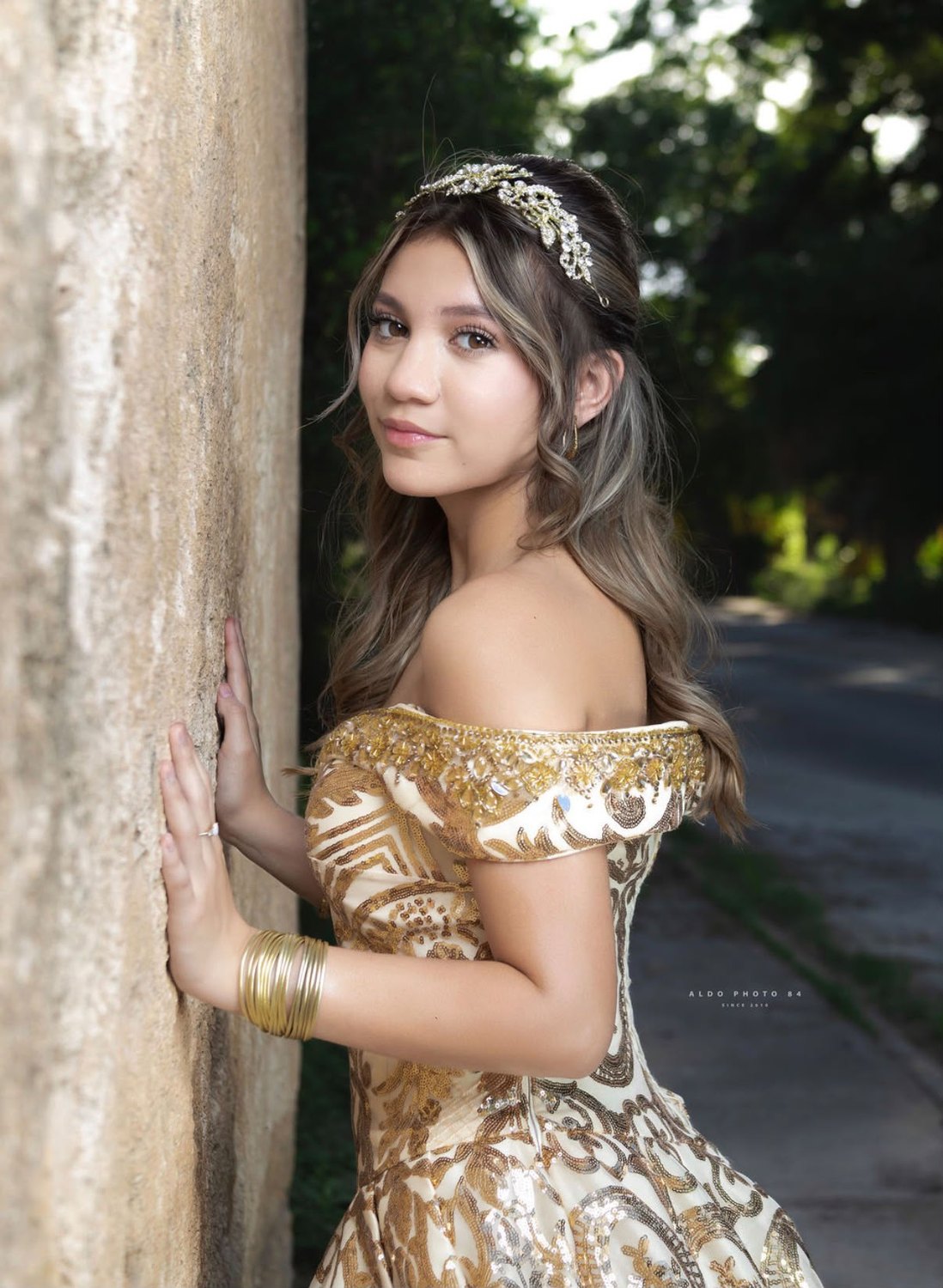 Quinceañera junto a muro de piedra